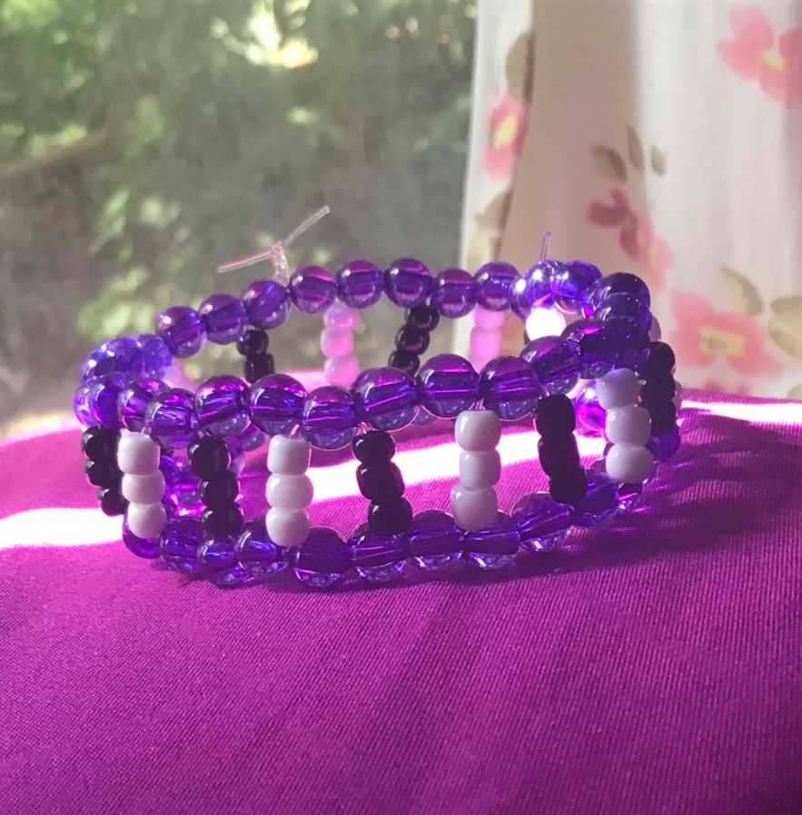 Simplistic bar cuff, made up of two purple singles, and black and white beads tying them together.