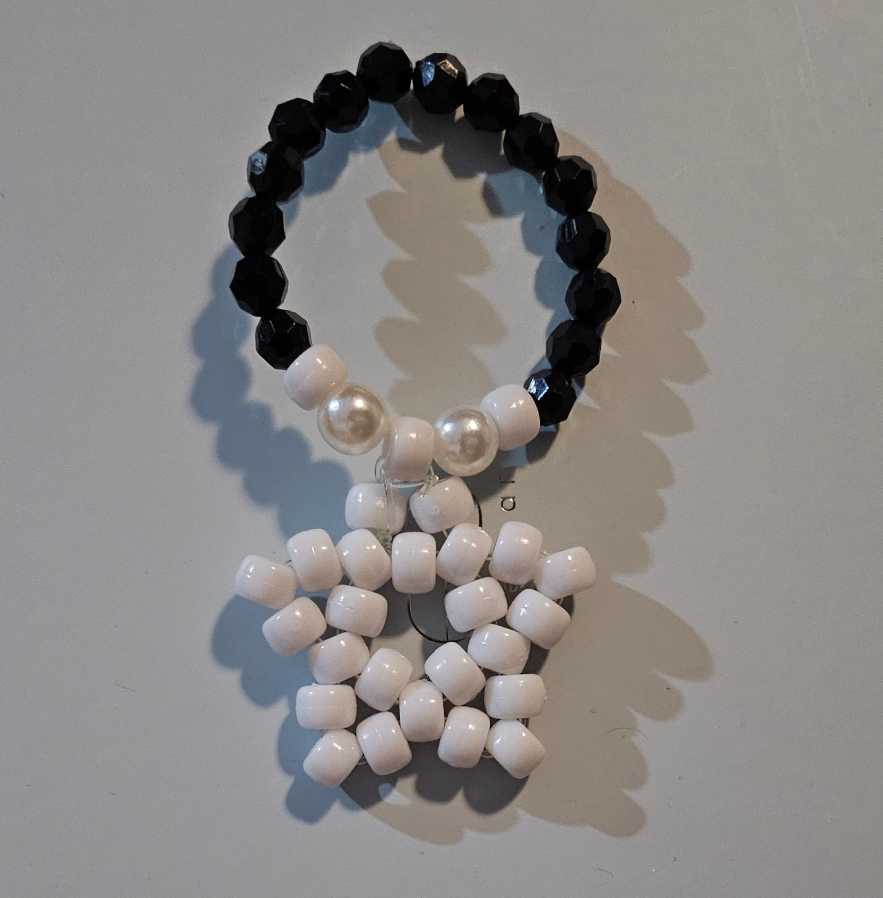 A black and white kandi single with a white star kandi charm attached.